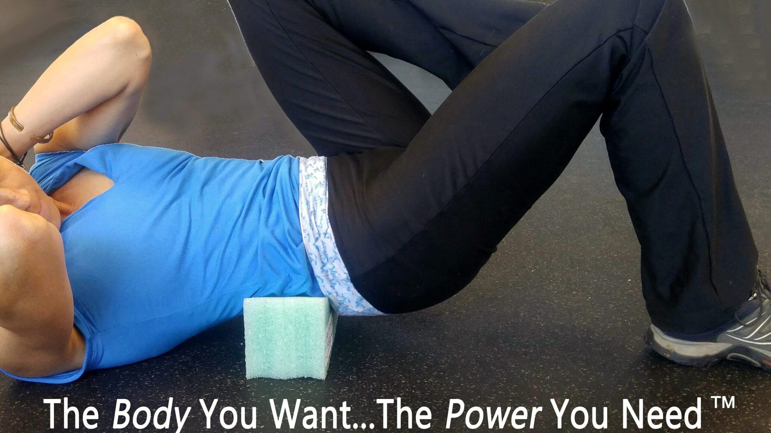 Person exercising on the floor wearing blue and black workout clothes.